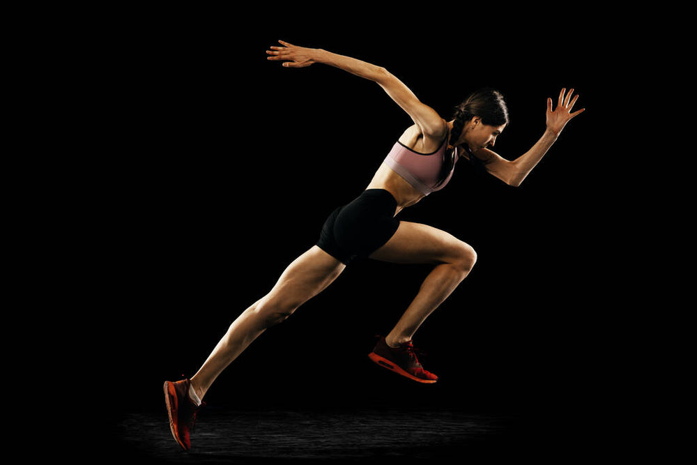 Young woman doing push-ups on a dark background. Studio shot